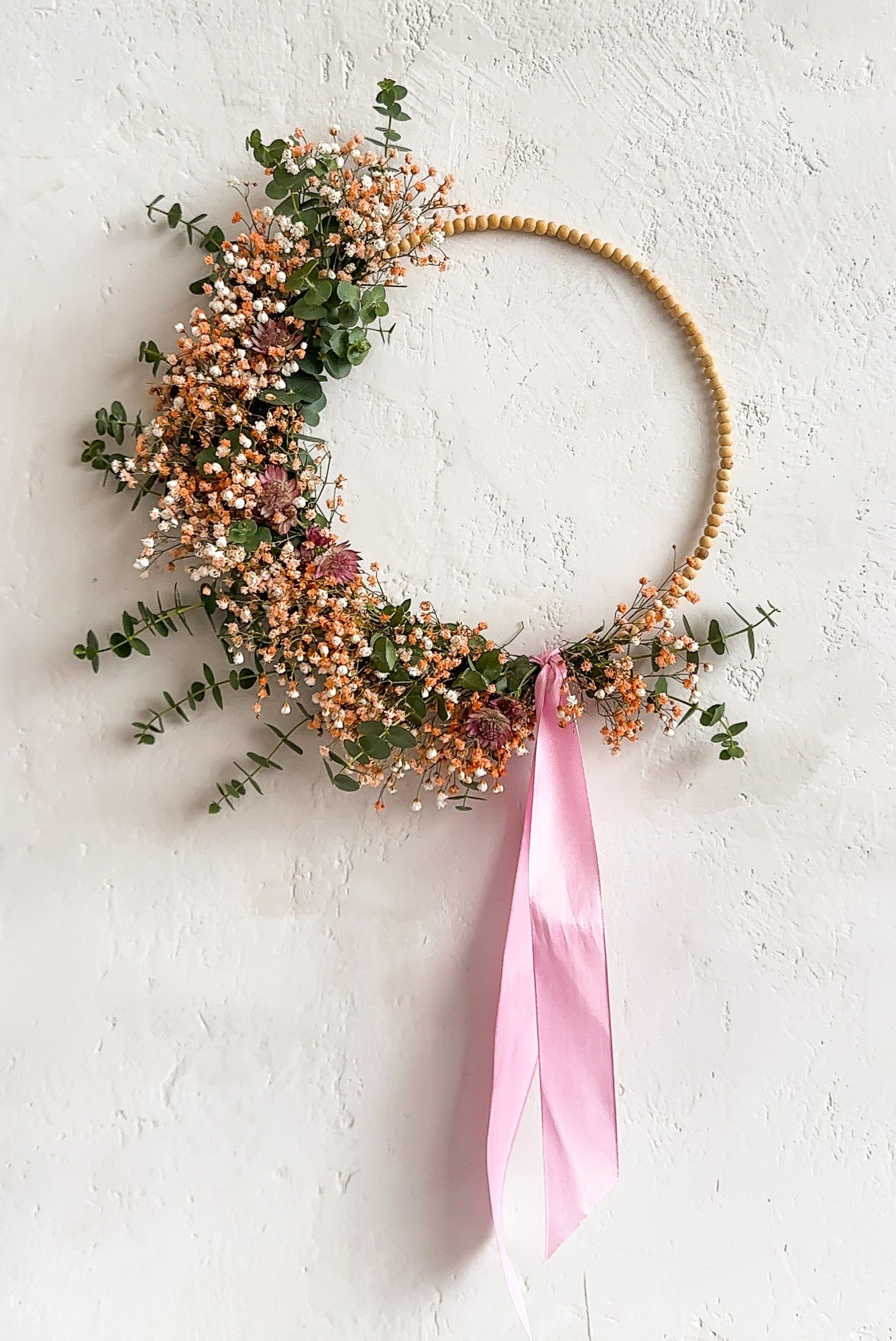 Pavasara vai Lieldienu vainags uz koka pērļu pamatnes.