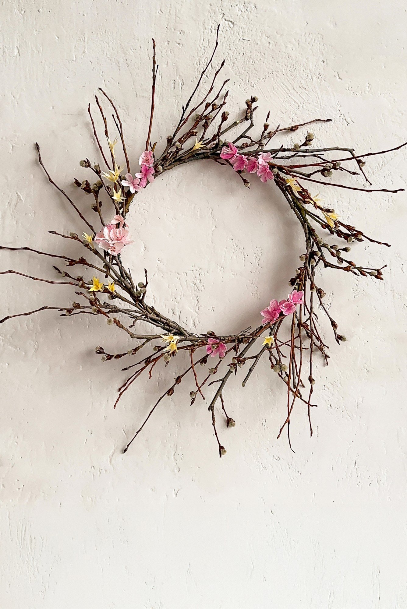 Pavasara vai Lieldienu vainags, dekorēts ar kreppapīra ziediem.