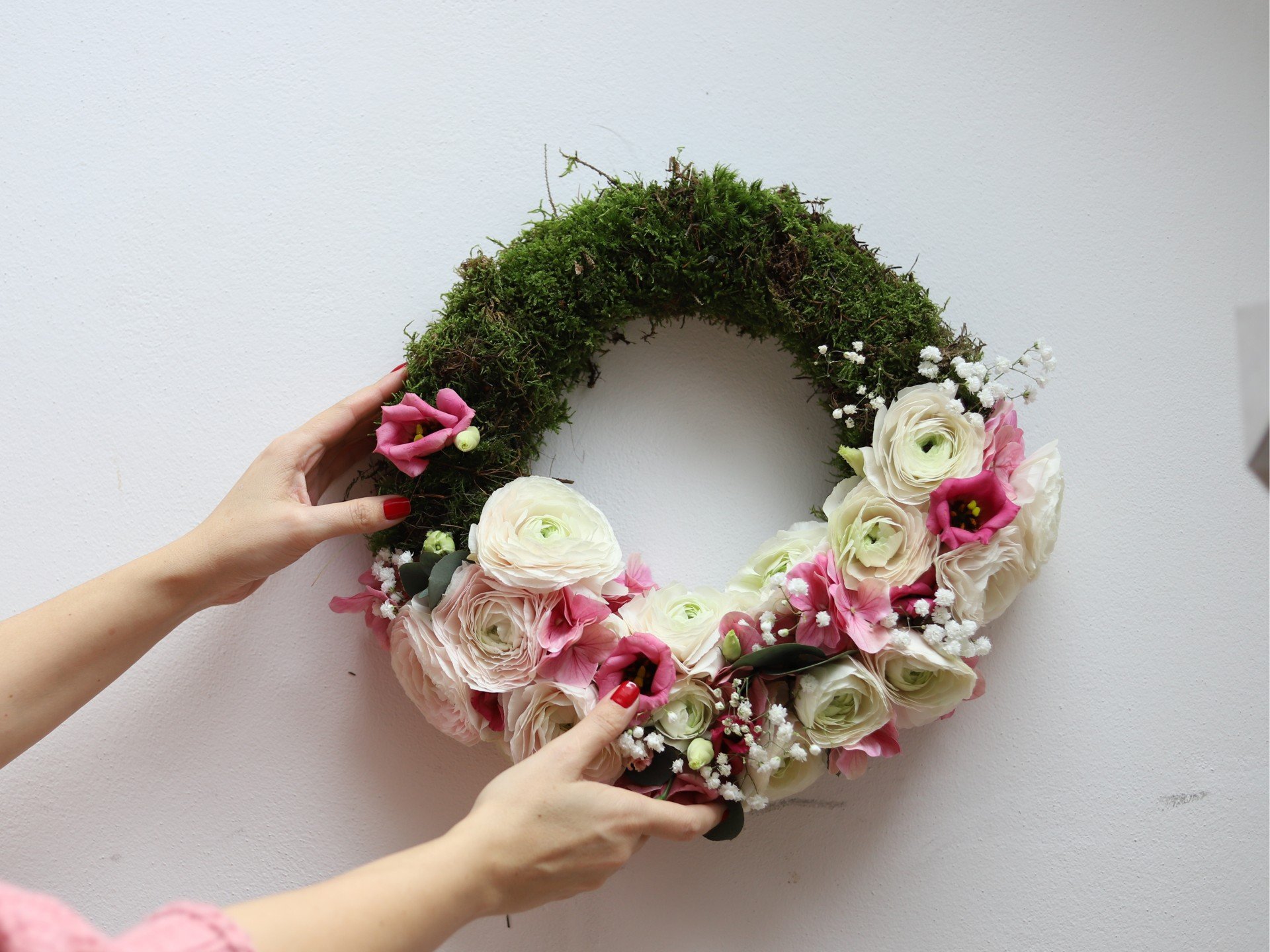 Pavasara vainags ar rozā un baltām Āzijas gundegām turēsies, pateicoties pamatnei no floristikas materiāla.