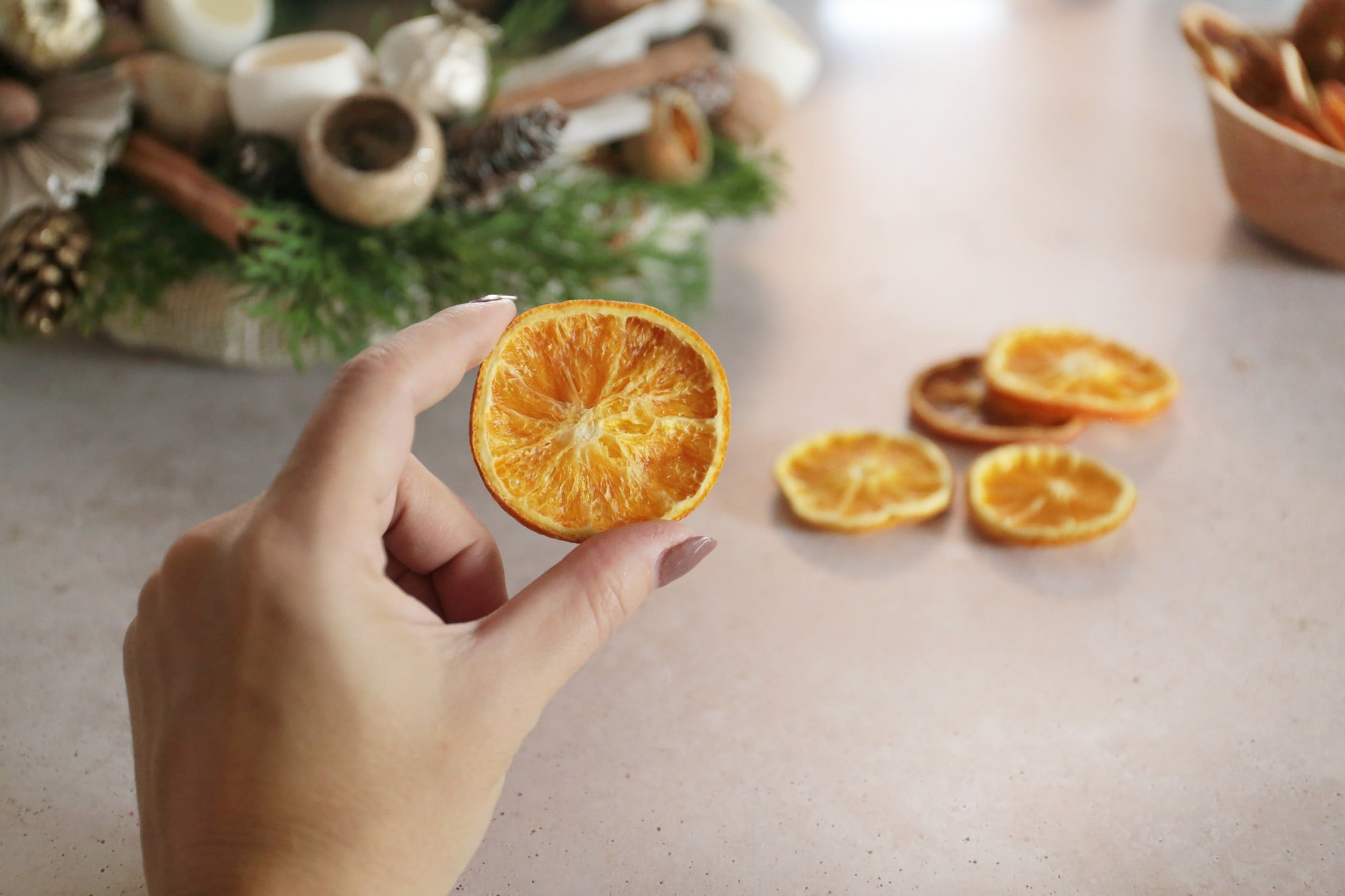 4. Pievienojiet priežu čiekurus, kanēļa standziņas un kaltētas apelsīnu šķēles.