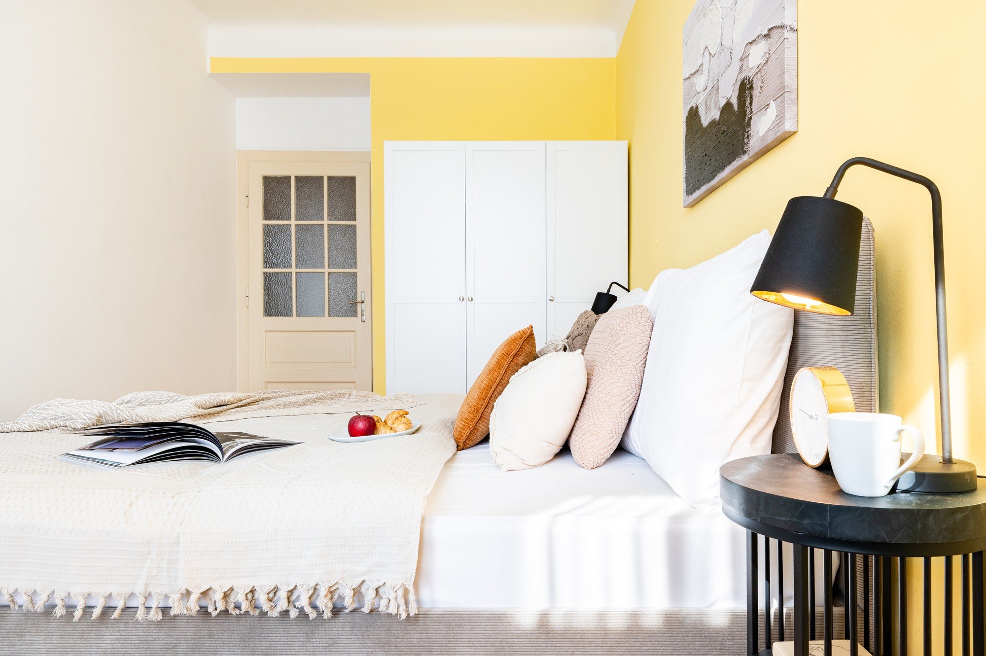 Telpa ir svaiga, optimistiska un harmoniska, ar siltu dzelteno akcentu, slāņotiem tekstilmateriāliem un detaļām, kas guļamistabu padara par mājīgu, bet vienlaikus modernu atpūtas vietu.